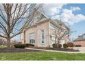 Charming side view of a brick home with a well-kept lawn and mature trees at 11106 Muirfield Trce, Fishers, IN 46037