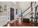 Inviting foyer featuring hardwood floors, elegant staircase, and stylish decor at 11106 Muirfield Trce, Fishers, IN 46037