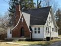 Charming two-story home featuring a brick chimney and a well-maintained landscaped yard at 2029 W 60Th St, Indianapolis, IN 46228