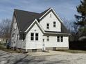 View of home's back exterior featuring white siding, a new roof, and a concrete driveway at 2029 W 60Th St, Indianapolis, IN 46228