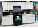 Kitchen with white cabinets and black appliances at 3128 S Holt Rd, Indianapolis, IN 46221