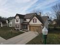 Well-maintained two-story home with a two-car garage, blue front door, and a beautifully landscaped yard at 3656 Homestead E Cir, Plainfield, IN 46168