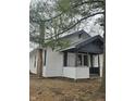 Side view of a charming bungalow showcasing its white siding and black accents at 4041 Boulevard Pl, Indianapolis, IN 46208