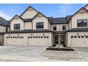Modern townhome featuring light beige siding, black trim, and individual garages at 4195 Douro Trl, Westfield, IN 46062