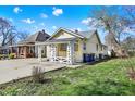 Inviting yellow home with decorative front porch, complemented by lush green surroundings at 4632 Normal Ave, Indianapolis, IN 46226