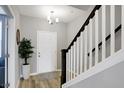 Elegant entryway with a white door, staircase, and a large plant at 6559 Seabiscuit Rd, Whitestown, IN 46075