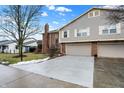 Townhouse with gray siding and brick accents, two-car garage, and small front yard at 7564 Farm View E Cir, Indianapolis, IN 46256