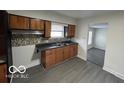 Functional kitchen features wood cabinetry, neutral countertops, and mosaic tile backsplash at 9820 E 12Th St, Indianapolis, IN 46229