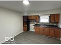Functional kitchen features wood cabinetry, neutral countertops, and mosaic tile backsplash at 9820 E 12Th St, Indianapolis, IN 46229