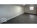 Spacious living room with sleek gray vinyl flooring and a window at 9820 E 12Th St, Indianapolis, IN 46229
