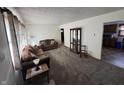 Spacious living room with brown couches, a display cabinet, and view into kitchen at 100 S Manhattan Ave, Muncie, IN 47303