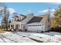 Beige vinyl sided home with a white garage door and a covered front porch at 10322 Sage Ct, Noblesville, IN 46060