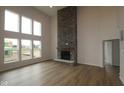 Bright living room with tall stone fireplace, large windows, and hardwood floors, creating a cozy and inviting space at 1144 Ridgevine Rd, Greenwood, IN 46143