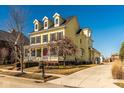 Spacious two-story yellow home with a welcoming front porch and a long driveway at 12020 Leighton Ct, Carmel, IN 46032