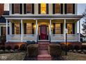 Inviting front porch with brick steps, white columns, and outdoor lighting for cozy evenings at 12020 Leighton Ct, Carmel, IN 46032