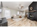 Spacious living room boasting hardwood floors, large windows, a ceiling fan and a modern brick fireplace at 12301 Van Spronsen Ct, Indianapolis, IN 46236