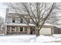Charming two-story home featuring a cozy front porch and an attached garage partially obscured by a leafless tree at 12643 Feldspar Rd, Indianapolis, IN 46236