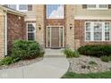 Elegant front entrance with a stone facade, manicured bushes, and a pathway at 18725 Wychwood Pl, Noblesville, IN 46062