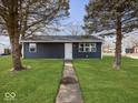 Newly built home with a dark blue exterior, well-manicured lawn, and walkway at 403 Wellington Blvd, Shelbyville, IN 46176