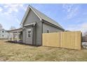 Gray home showcasing a new wooden fence, siding and gabled roof at 429 Wood St, Greenfield, IN 46140