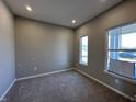 Bright bedroom features neutral walls, plush carpet, two windows, and modern recessed lighting at 450 Atlas Dr, Lebanon, IN 46052