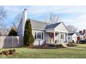 Gray house with a wood fence, landscaping, and a spacious yard at 5449 Indianola Ave, Indianapolis, IN 46220