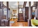 Inviting foyer with hardwood floors, decorative columns, and staircase with rich woodwork at 625 Sanders St, Indianapolis, IN 46203