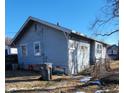 Rear view of a light blue bungalow with a small yard and alley at 710 N Drexel Ave, Indianapolis, IN 46201