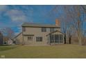Spacious backyard featuring a screened-in porch, patio, and large grassy area at 10823 Knightsbridge Ln, Fishers, IN 46037