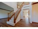 Inviting foyer with a grand staircase, hardwood floors, and wainscoting at 10823 Knightsbridge Ln, Fishers, IN 46037
