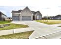 Two-story home with gray brick exterior and a three-car garage at 11722 Platt St, Noblesville, IN 46060