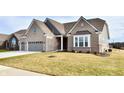 Two-story home with gray brick exterior and a three-car garage at 11722 Platt St, Noblesville, IN 46060