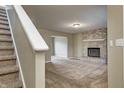 Cozy living room with a brick fireplace, plush carpet, and staircase at 1229 Tealpoint Cir, Indianapolis, IN 46229