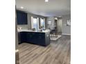 Open kitchen with navy cabinets, quartz countertop island, and a view into the dining area at 2426 S Holt S Rd, Indianapolis, IN 46241