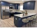 Modern kitchen boasts navy cabinets, quartz countertops, and stainless steel appliances for a sleek design at 2426 S Holt S Rd, Indianapolis, IN 46241