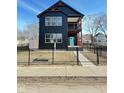 Two-story modern farmhouse with black exterior, fenced yard, and a teal front door at 337 N Beville Ave, Indianapolis, IN 46201