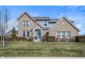 Charming two-story home with brick and stone accents, a manicured lawn, and a welcoming blue front door at 377 Morningside Dr, Brownsburg, IN 46112