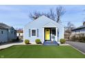 Charming light blue house with a bright yellow door, gray trim, and a green front yard at 3910 E 34Th St, Indianapolis, IN 46218
