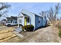 Charming light blue house with a bright yellow door, gray trim, and a small front yard at 3910 E 34Th St, Indianapolis, IN 46218
