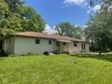 Expansive backyard featuring a white brick house, patio, and lots of green grass at 5324 Mann Rd, Indianapolis, IN 46221