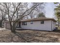 Side view of a freshly painted white brick ranch home with a patio at 5324 Mann Rd, Indianapolis, IN 46221