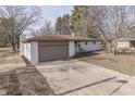 White brick ranch house with a brown roof, attached garage, and spacious yard at 5324 Mann Rd, Indianapolis, IN 46221