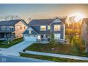 Two-story home with two-car garage, well-kept lawn, and landscaping nestled between other homes in a cozy neighborhood at 9812 Ridgecrest Ln, McCordsville, IN 46055