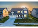 Beautiful two-story home with lush lawn, landscaping, and a two-car garage in a quiet neighborhood, lit by the rising sun at 9812 Ridgecrest Ln, McCordsville, IN 46055