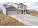 Charming home boasting a large driveway and attached garage with a combination brick and vinyl exterior at 101 Ames Dr, Whiteland, IN 46184
