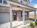 Close-up of the front porch, showcasing its brick pillars, modern lighting, and a stylish front door at 101 Ames Dr, Whiteland, IN 46184