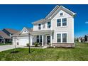 Inviting two-story home with a landscaped lawn, an attached two car garage and covered front porch at 11034 Saddlebred Dr, Indianapolis, IN 46239