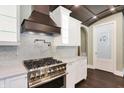 Modern kitchen with stainless steel appliances, pot filler, white cabinets, and pantry at 11710 Cold Creek Ct, Zionsville, IN 46077