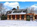 Beautiful log cabin with snow-covered roof, and a cozy inviting front porch at 1307 W 161St St, Westfield, IN 46074