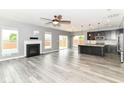 Open concept living and kitchen space, with fireplace, hardwood floors and a large island with pendant lights at 1324 Trailside Dr, Greenwood, IN 46143